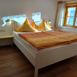 Schlafzimmer mit Doppelbett und offenem Fußbereich